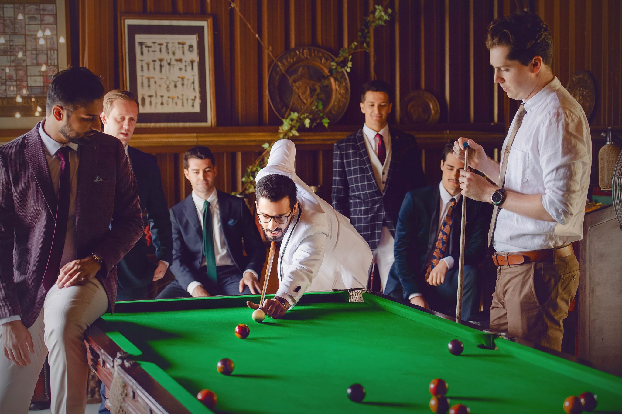 The boys are playing billiard with their suits