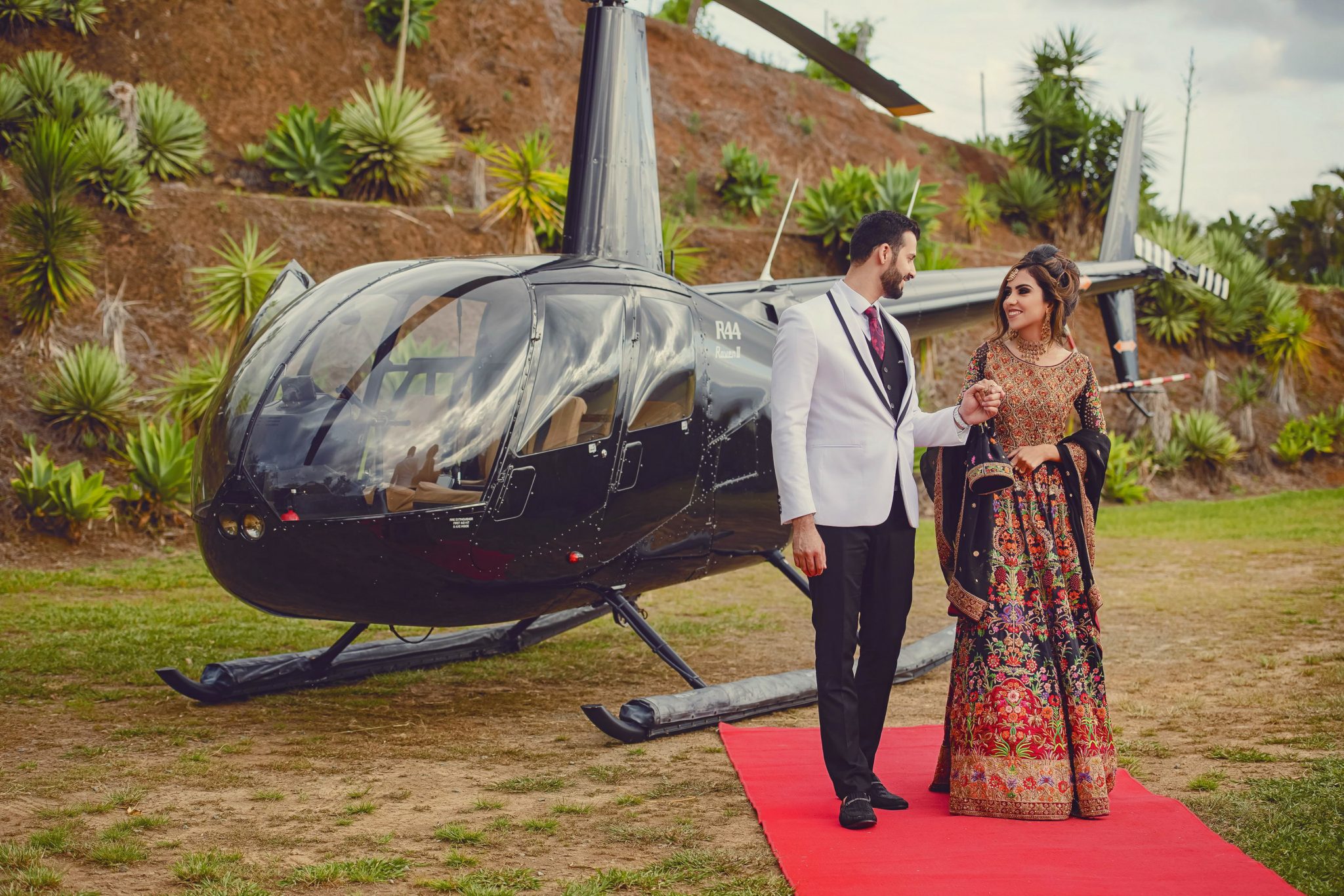 The Groom and Bride are standing in front of the black helicopter