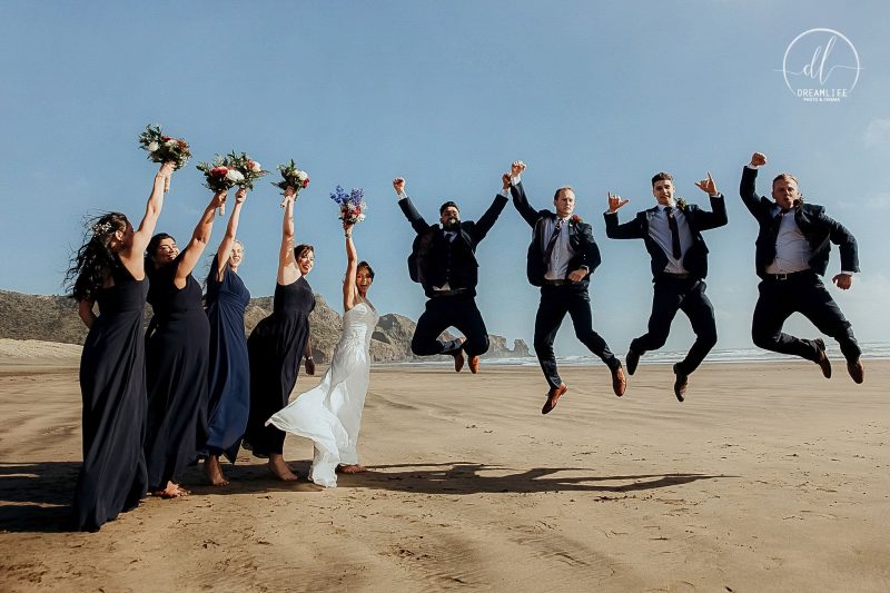 groom and bride with their entourage doing jump shots