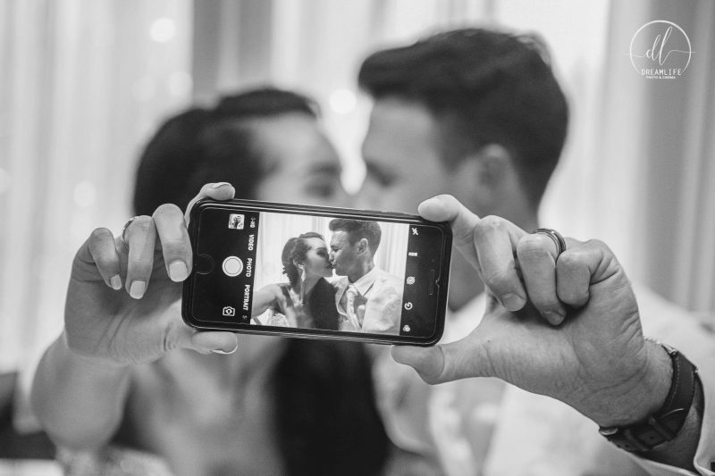 groom and bride holding an iphone