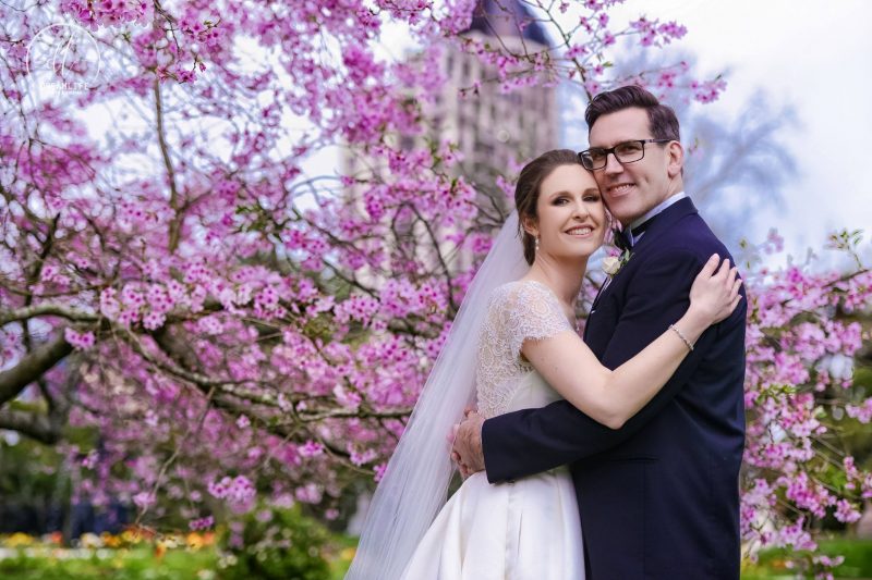 groom and bride in a cherry blossom like tree backdrop