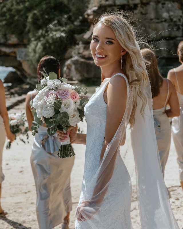 bride holding a flower bouquet with her bridesmaids