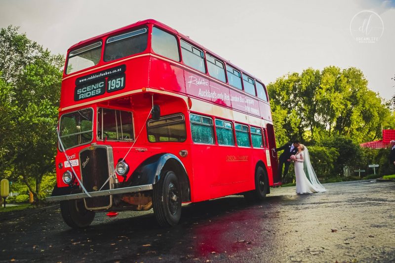 groom in a red bus hold his bride