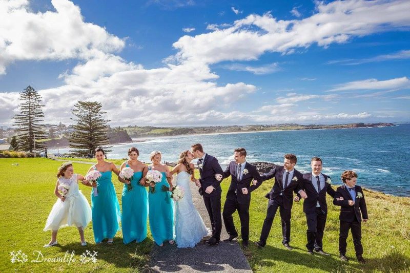 bride and groom with their entourage in a scenic backdrop