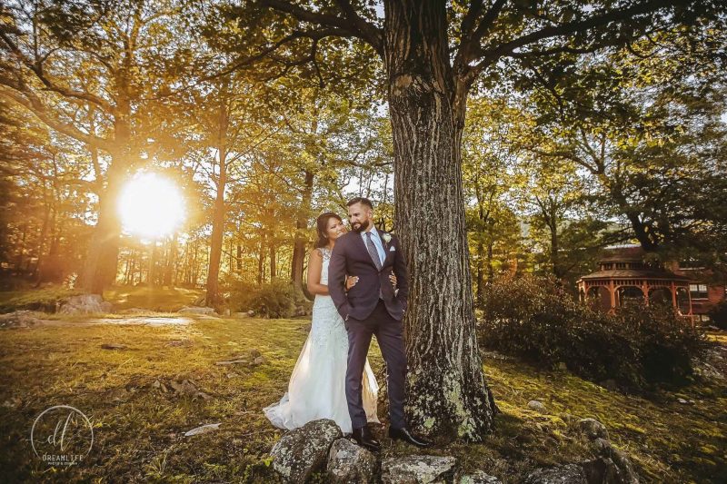 bride kissing groom in a forest and sunset backdrop