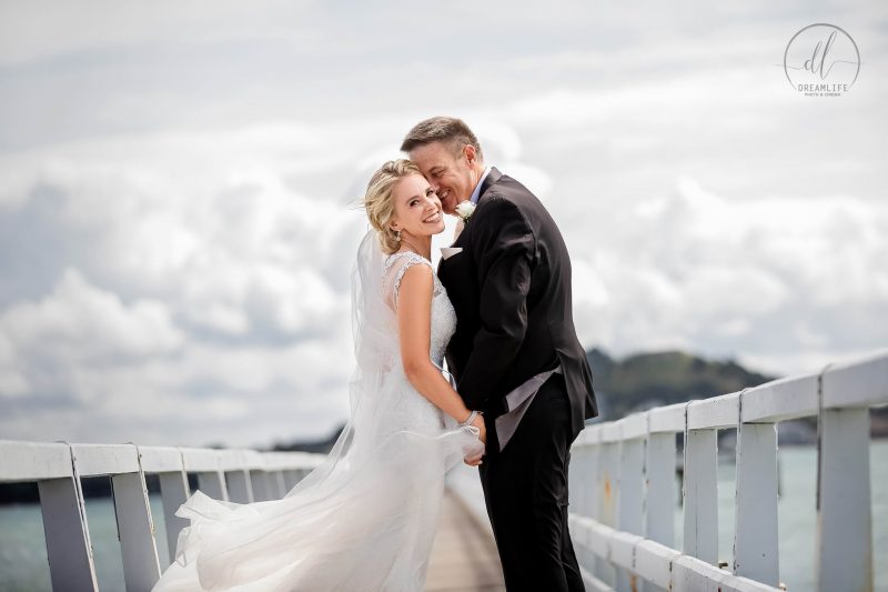 groom and bride in a bridge and sky backdrop