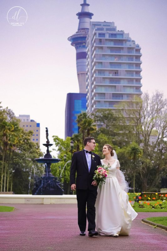 groom and bride walking with city building backdrop