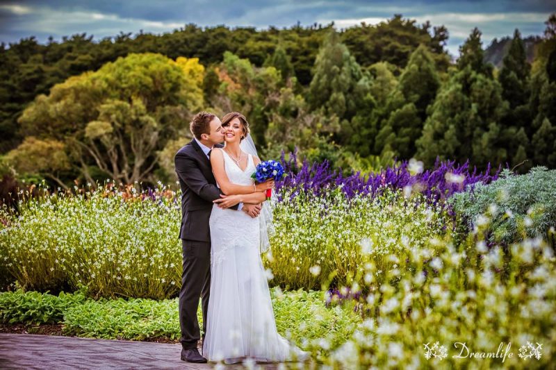 groom and bride in a garden with flowers