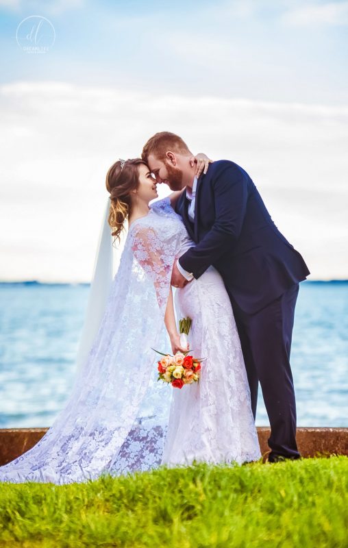 groom and bride kissing in an open sea backdrop