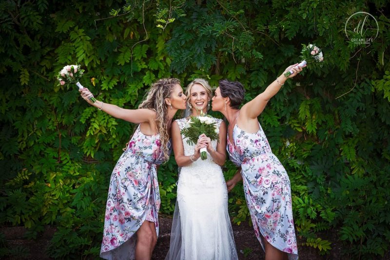 bride with her bridesmaids each holding a flower bouquet