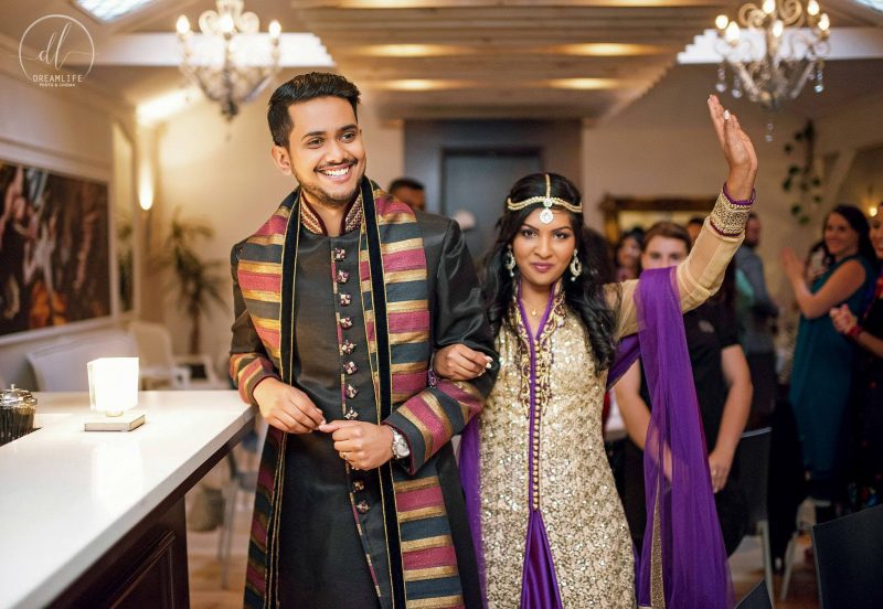 indian bride and groom walking into their wedding venue