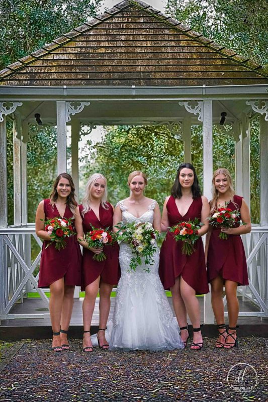 bride with her bridesmaids holding a flower boquet