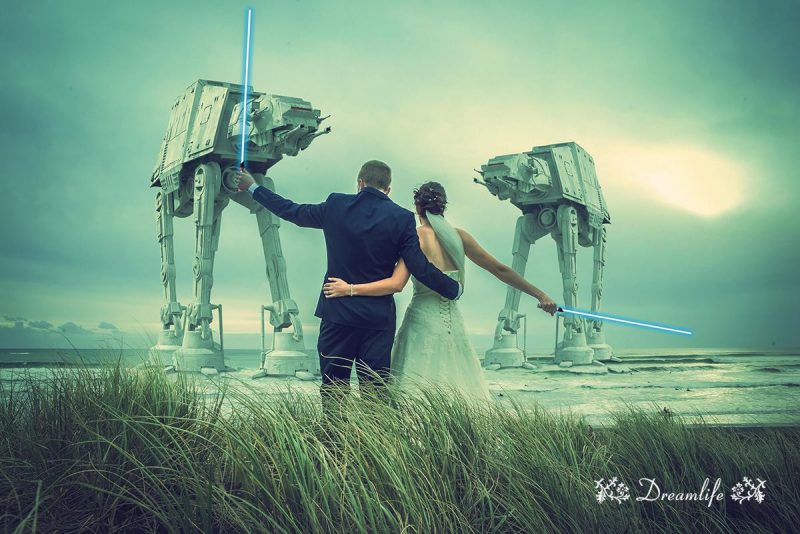groom and bride holding a lightsaber sword with two robots backdrop