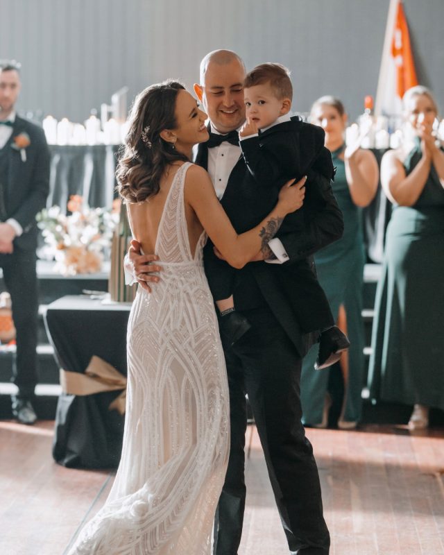 groom and bride with their child dancing in a wedding venue