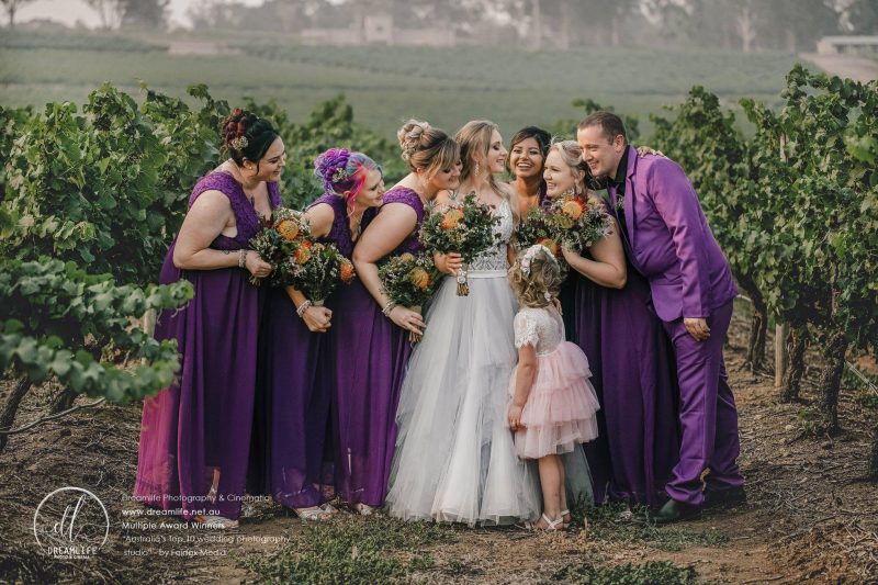 bride with her entourage in a vineyard backdrop